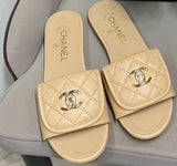 Channel flat slide slipper adorned with the iconic gold-tone Chanel CC logo