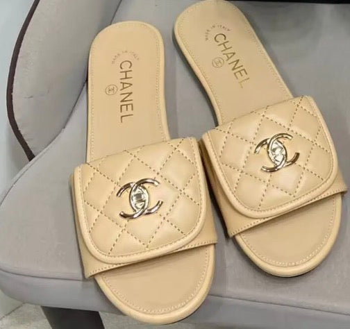 Channel flat slide slipper adorned with the iconic gold-tone Chanel CC logo