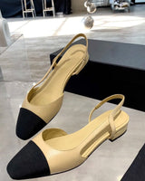 two-tone beige and black slingback shoe featuring a contrasting black cap toe and a small interlocking CC logo on the low block heel