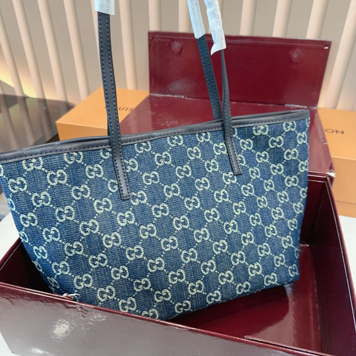 Comes with a box measuring 25*20 cm. This Gucci denim tote bag features GG Supreme monogram canvas with leather trim and handles, and a gold-tone metal logo plate. The bag has Gucci's classic structured tote silhouette, understated yet stylish, suitable for everyday wear without being too formal. (Ej)