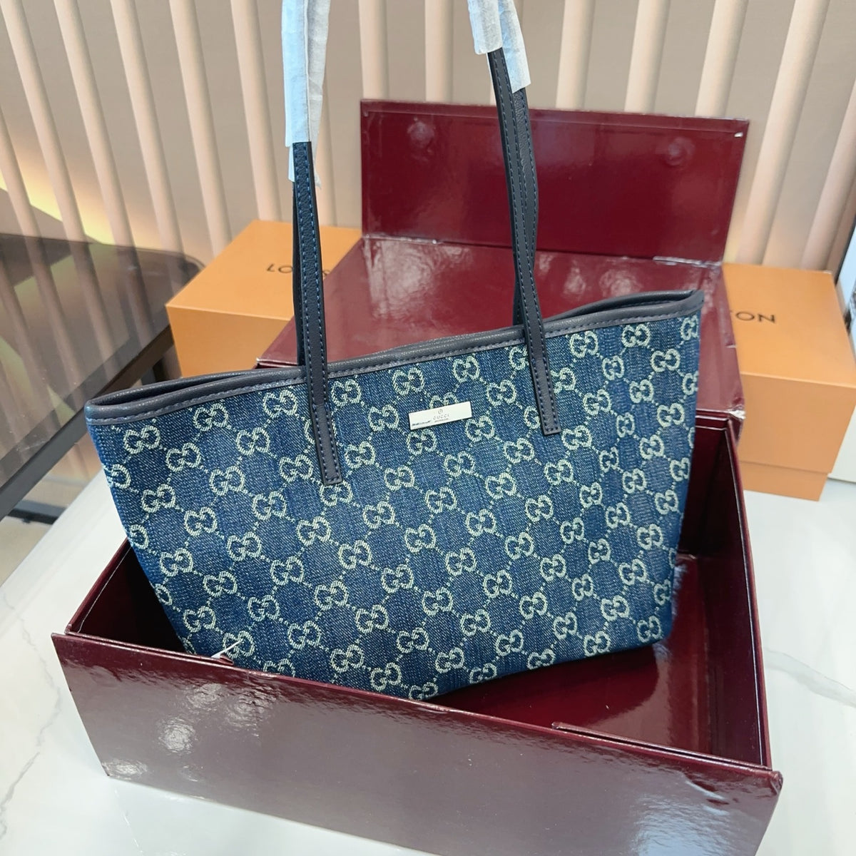 Comes with a box measuring 25*20 cm. This Gucci denim tote bag features GG Supreme monogram canvas with leather trim and handles, and a gold-tone metal logo plate. The bag has Gucci's classic structured tote silhouette, understated yet stylish, suitable for everyday wear without being too formal. (Ej)