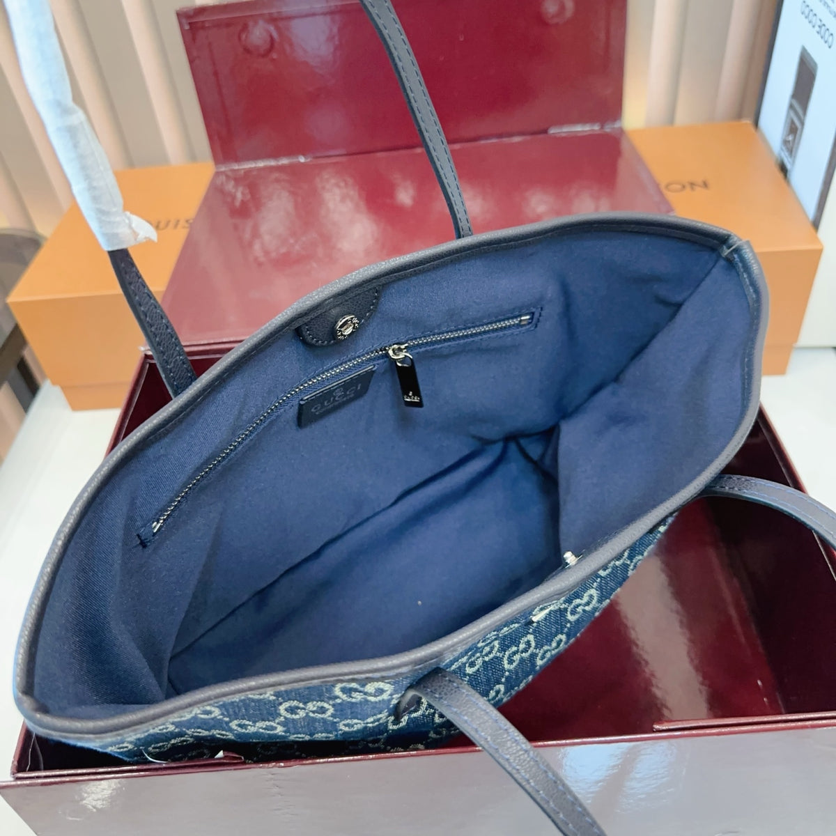 Comes with a box measuring 25*20 cm. This Gucci denim tote bag features GG Supreme monogram canvas with leather trim and handles, and a gold-tone metal logo plate. The bag has Gucci's classic structured tote silhouette, understated yet stylish, suitable for everyday wear without being too formal. (Ej)
