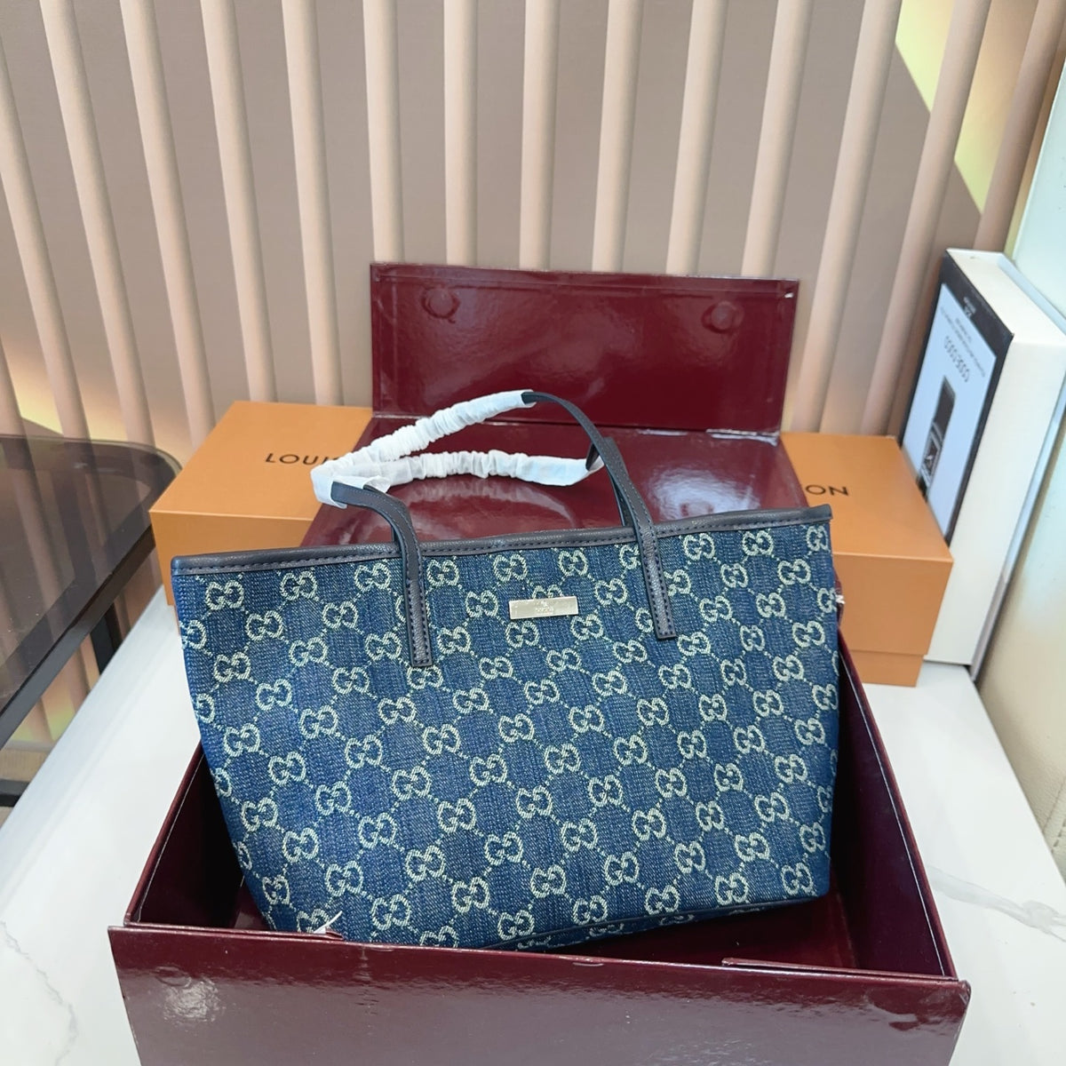 Comes with a box measuring 25*20 cm. This Gucci denim tote bag features GG Supreme monogram canvas with leather trim and handles, and a gold-tone metal logo plate. The bag has Gucci's classic structured tote silhouette, understated yet stylish, suitable for everyday wear without being too formal.