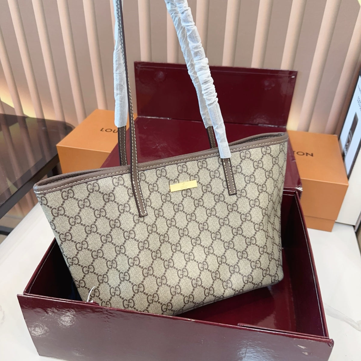 Comes with a box measuring 25*20 cm. This Gucci denim tote bag features GG Supreme monogram canvas with leather trim and handles, and a gold-tone metal logo plate. The bag has Gucci's classic structured tote silhouette, understated yet stylish, suitable for everyday wear without being too formal.